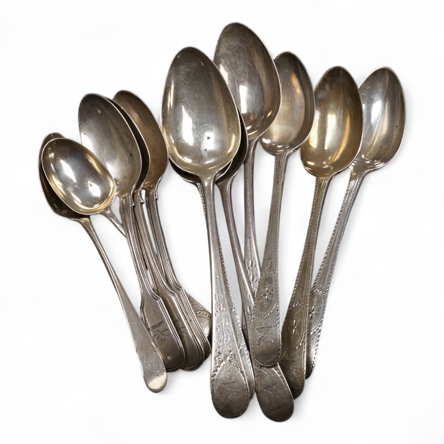 Seven assorted George III bright cut engraved silver Old English pattern table spoons, together with five other silver spoons, various dates and makers, 19.4oz.